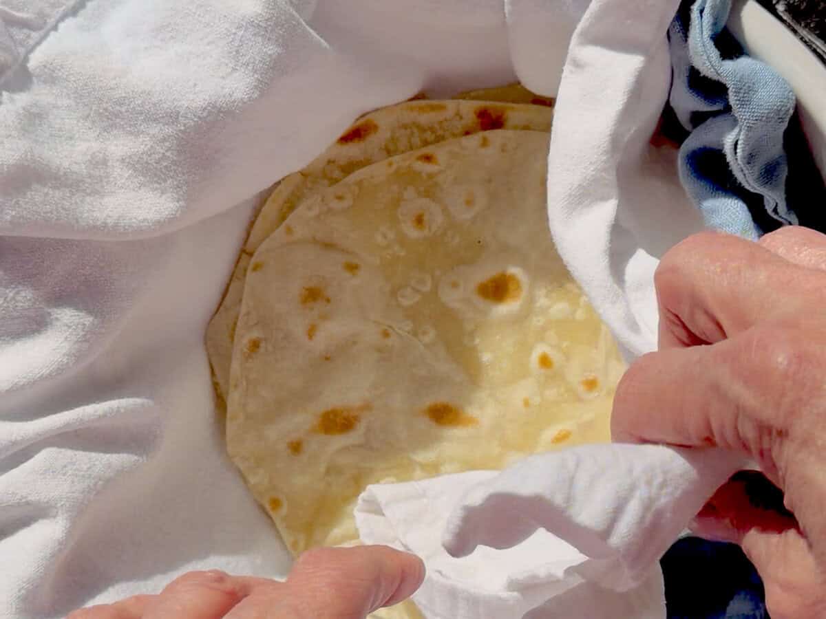 Wrapping flour tortillas in napkins to keep warm.