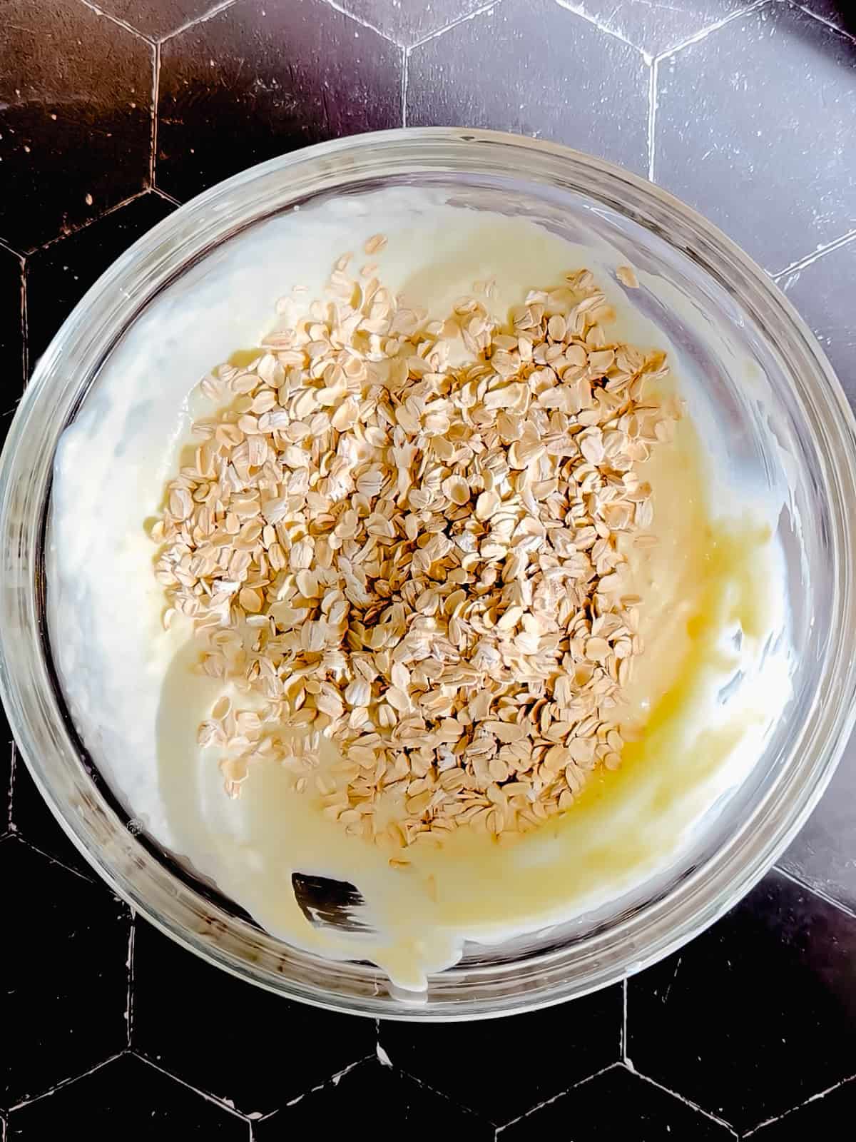 Adding quick oats to wet ingredients to make banana oat pancake pancakes.