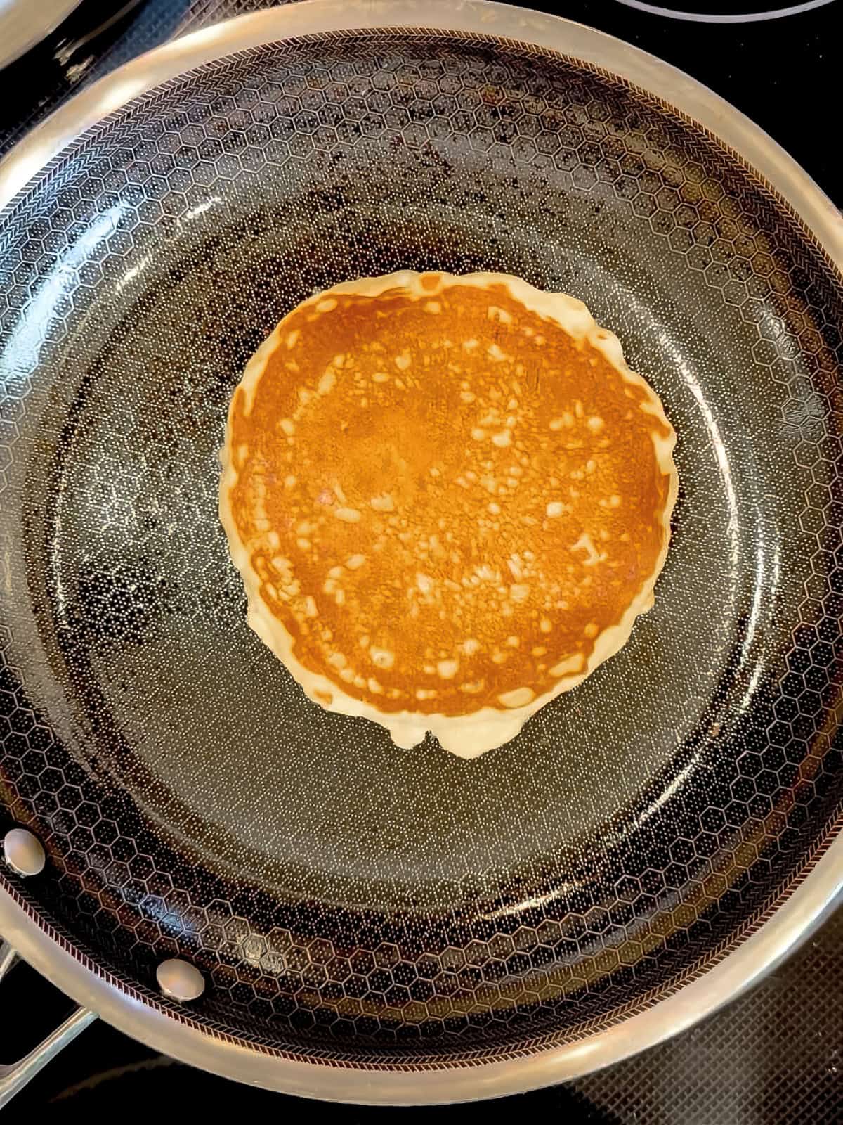 Banana oatmeal pancake in a black pan.