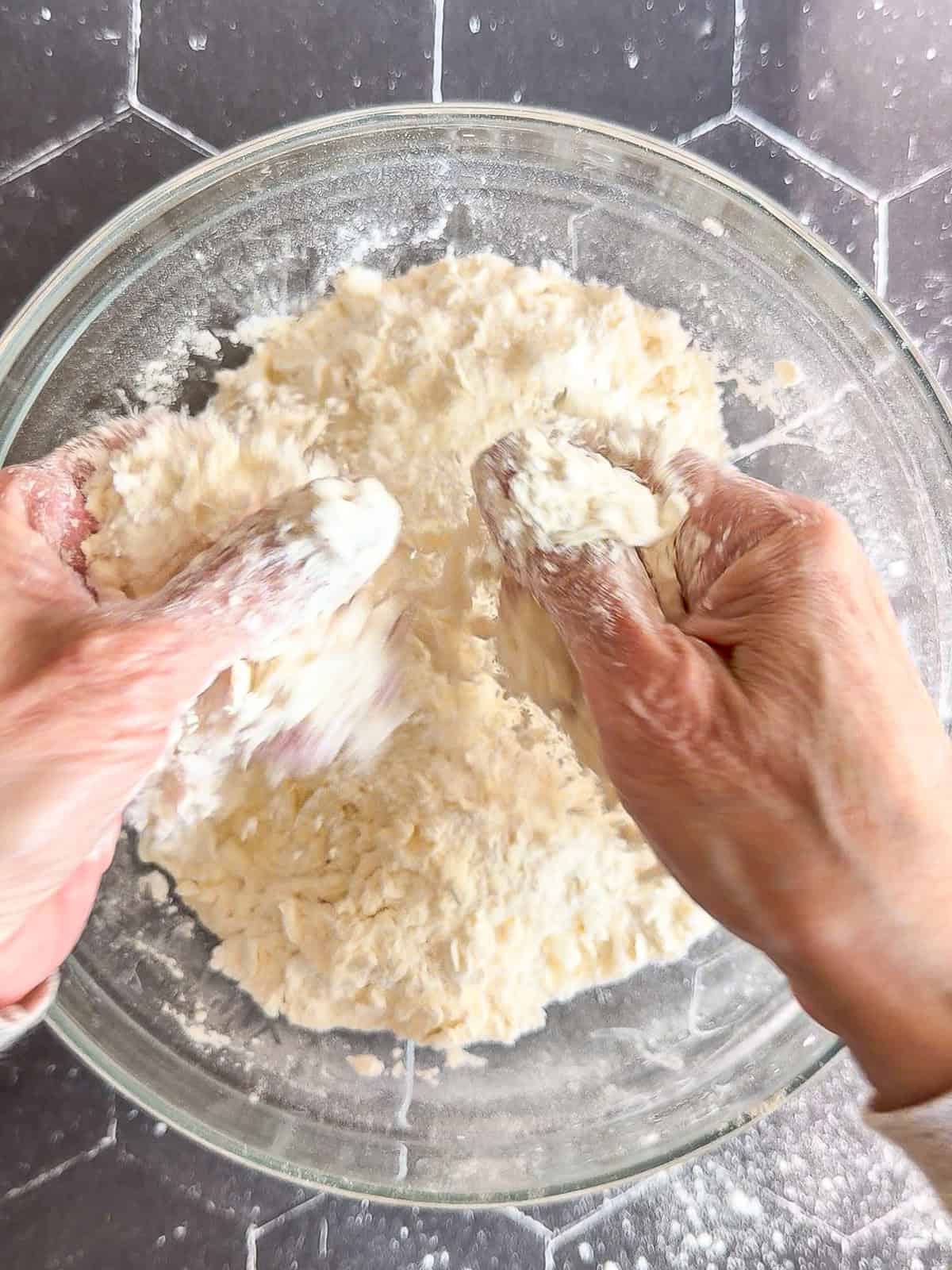 Using fingers to cut butter into dry ingredients.