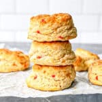 A stack of pimento cheese biscuits on parchment paper.