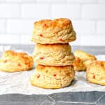 A stack of pimento cheese biscuits on parchment paper.