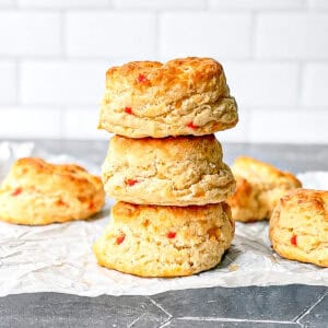 A stack of pimento cheese biscuits on parchment paper.