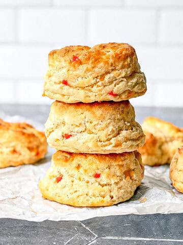 A stack of pimento cheese biscuits on parchment paper.
