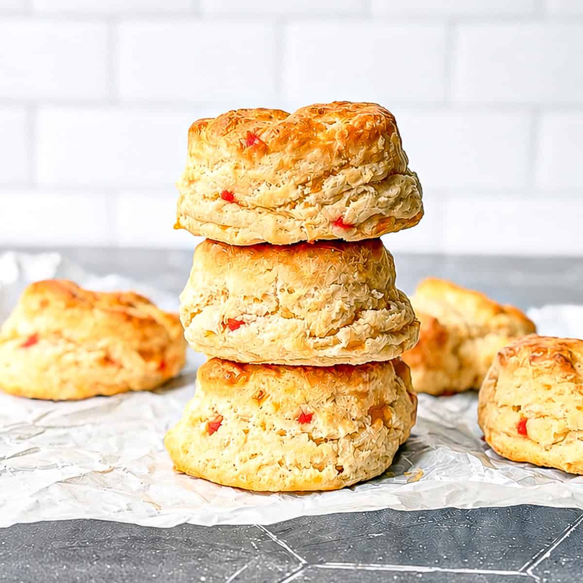 A stack of pimento cheese biscuits on parchment paper.
