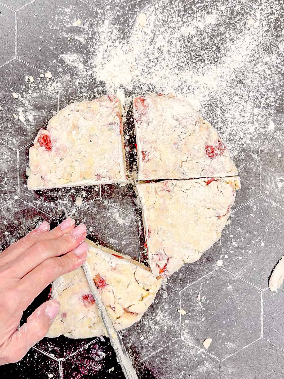 Using a knife to cut scone dough into wedges.