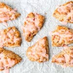 Glazed strawberry scones on parchment paper.