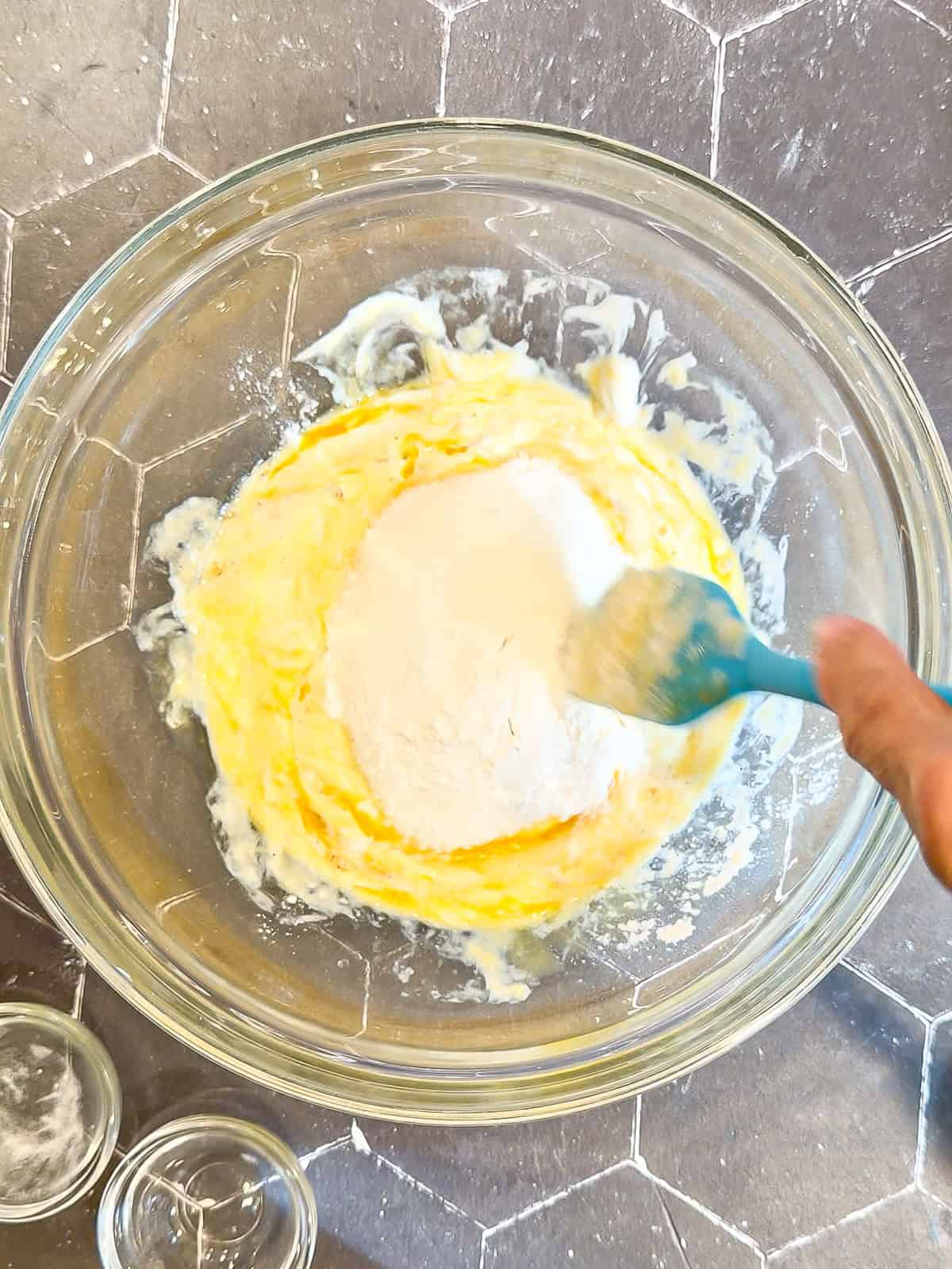 Mixing wet ingredients to make muffins in a glass bowl.