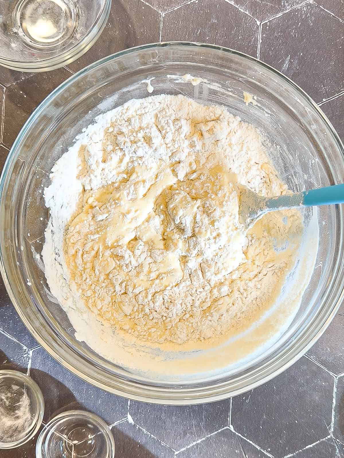 Mixing muffin batter in a glass bowl.