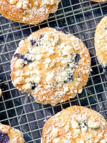 Top view of a blueberry muffin top on a wire rack.