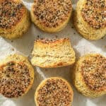 Cream cheese biscuits with everything seasoning on a parchment paper lined sheet pan.