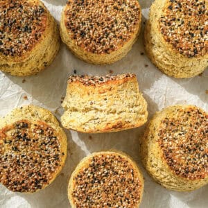 Cream cheese biscuits with everything seasoning on a parchment paper lined sheet pan.