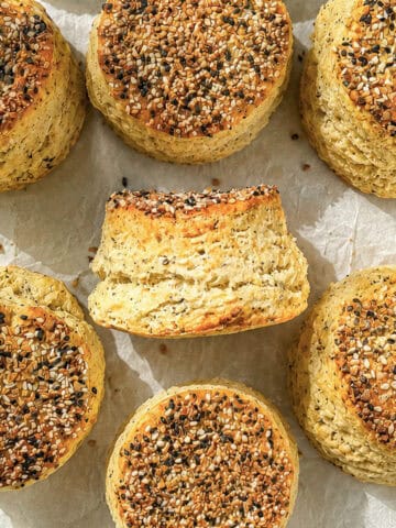 Cream cheese biscuits with everything seasoning on a parchment paper lined sheet pan.