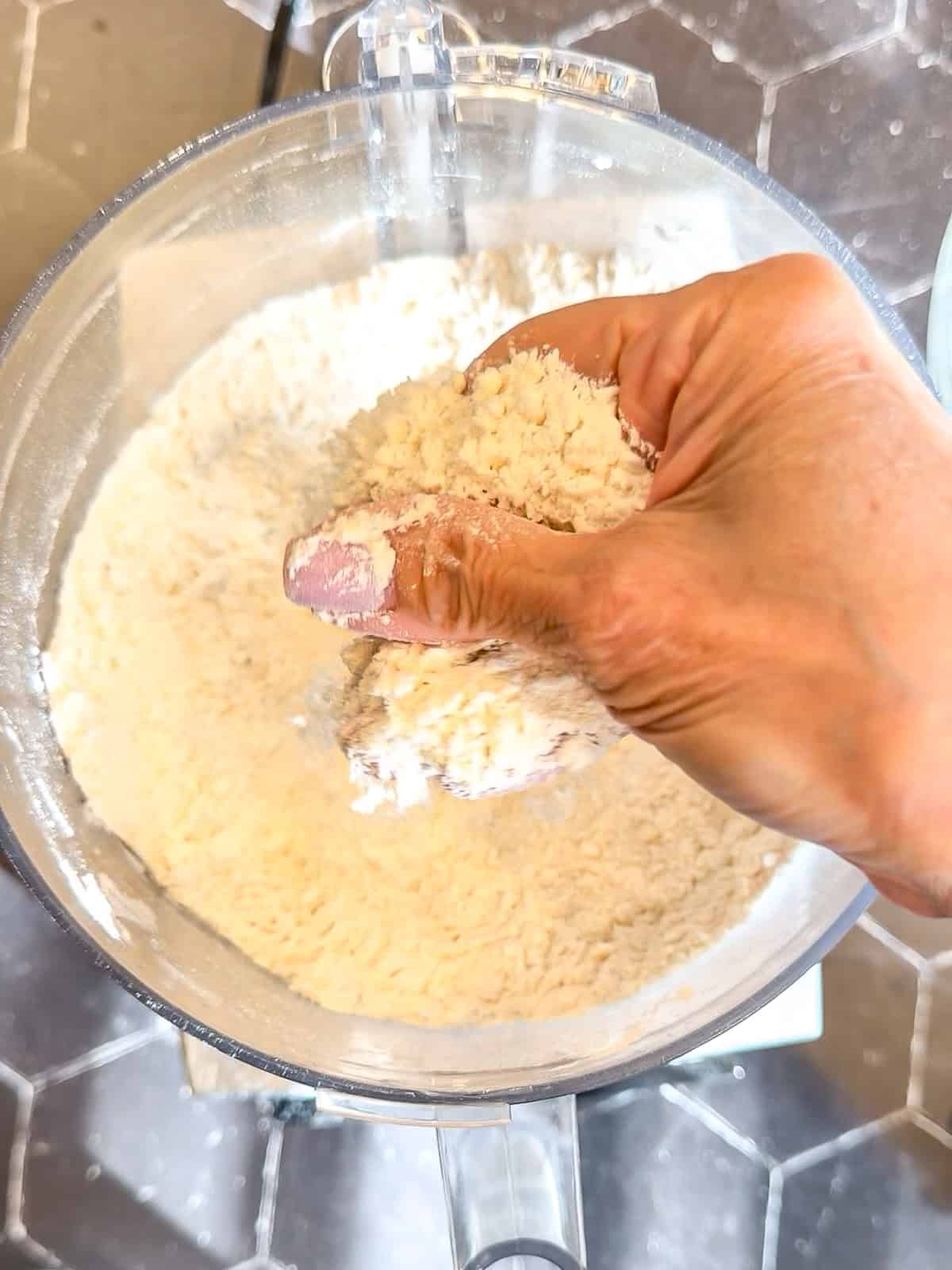 Checking the texture of flower and butter mixture in a food processor.