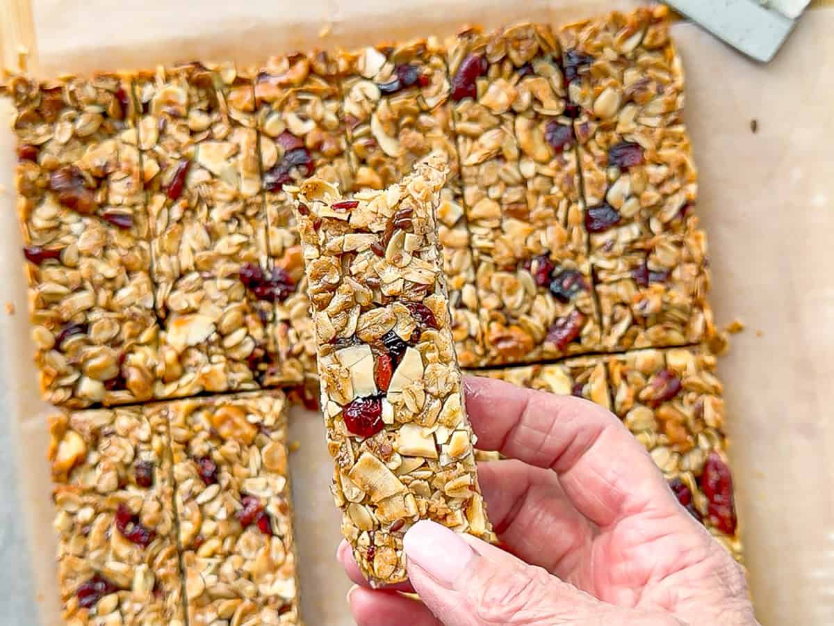 Author's hand holding a granola bar with a bite taken out.