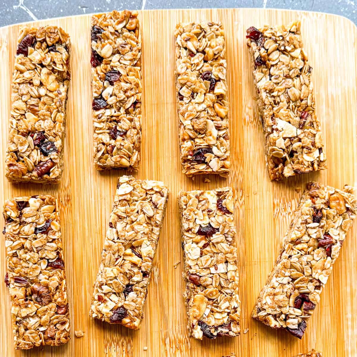 Granola bars on a wooden cutting board.
