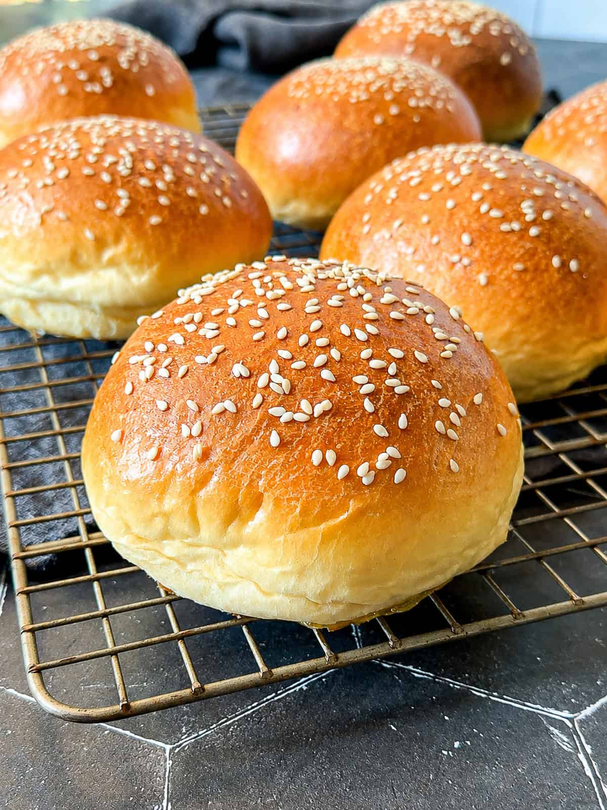 Hamburger buns on a wire rack.