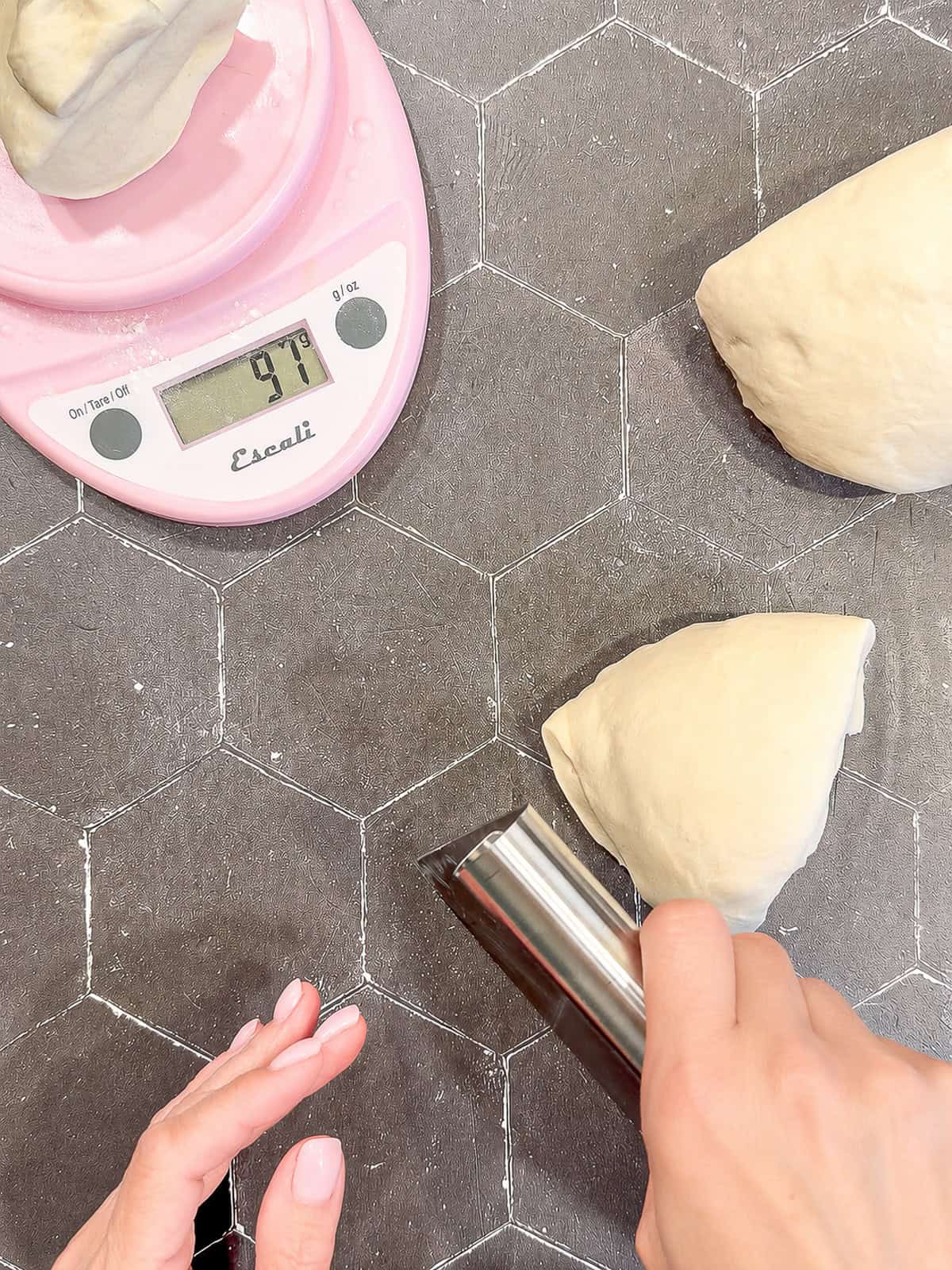 Weighing portions of dough with a pink scale.