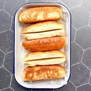 Hotdog buns in a tray.