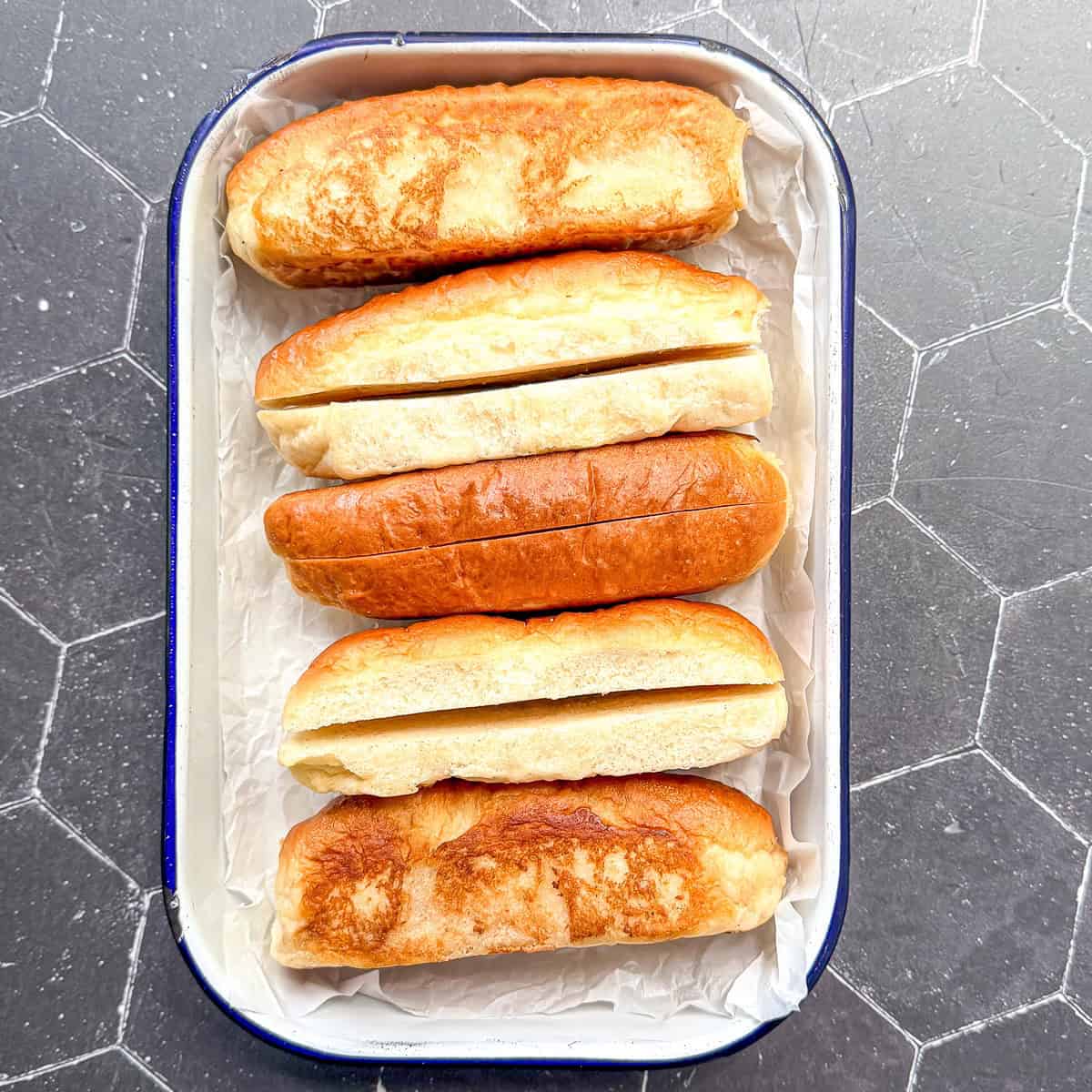 Hotdog buns in a tray.