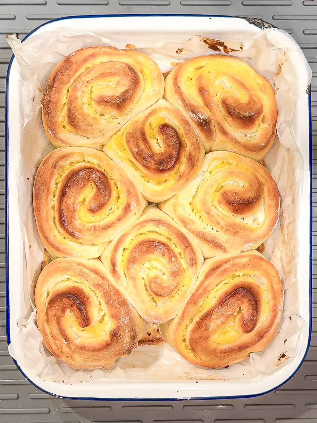Baked lemon rolls in a white pan.