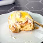 Side view of a lemon roll with cream cheese frosting and lemon curd on top