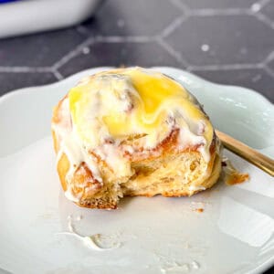 Side view of a lemon roll with cream cheese frosting and lemon curd on top