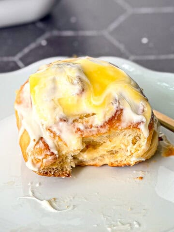 Side view of a lemon roll with cream cheese frosting and lemon curd on top