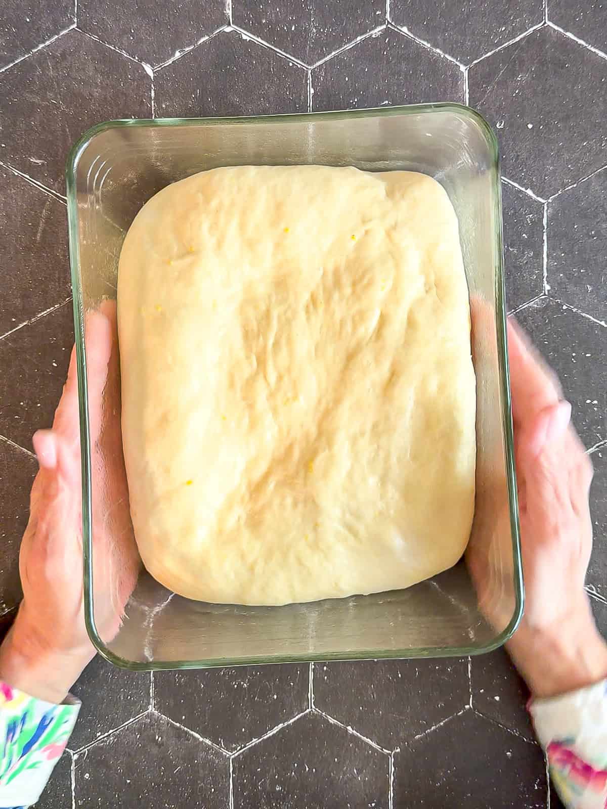 Fully risen dough in a rectangular glass baking dish.