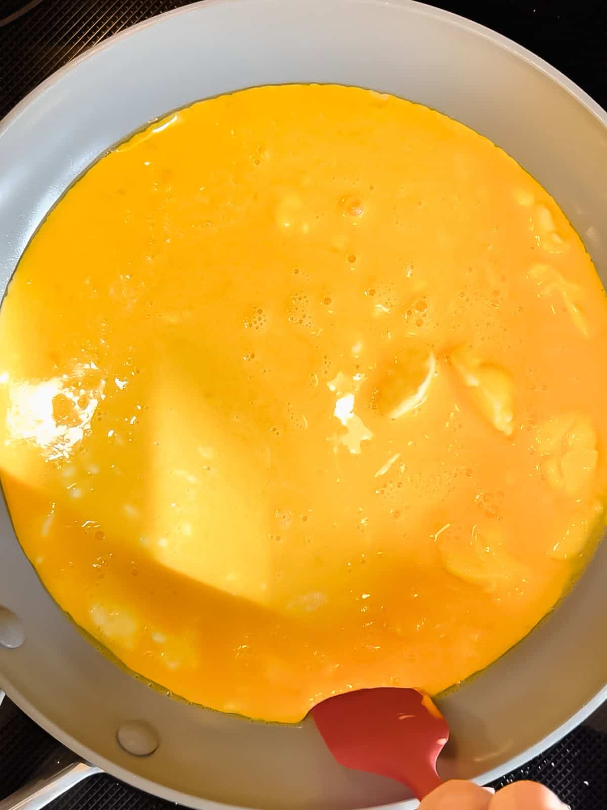 Uncooked eggs in a nonstick pan.