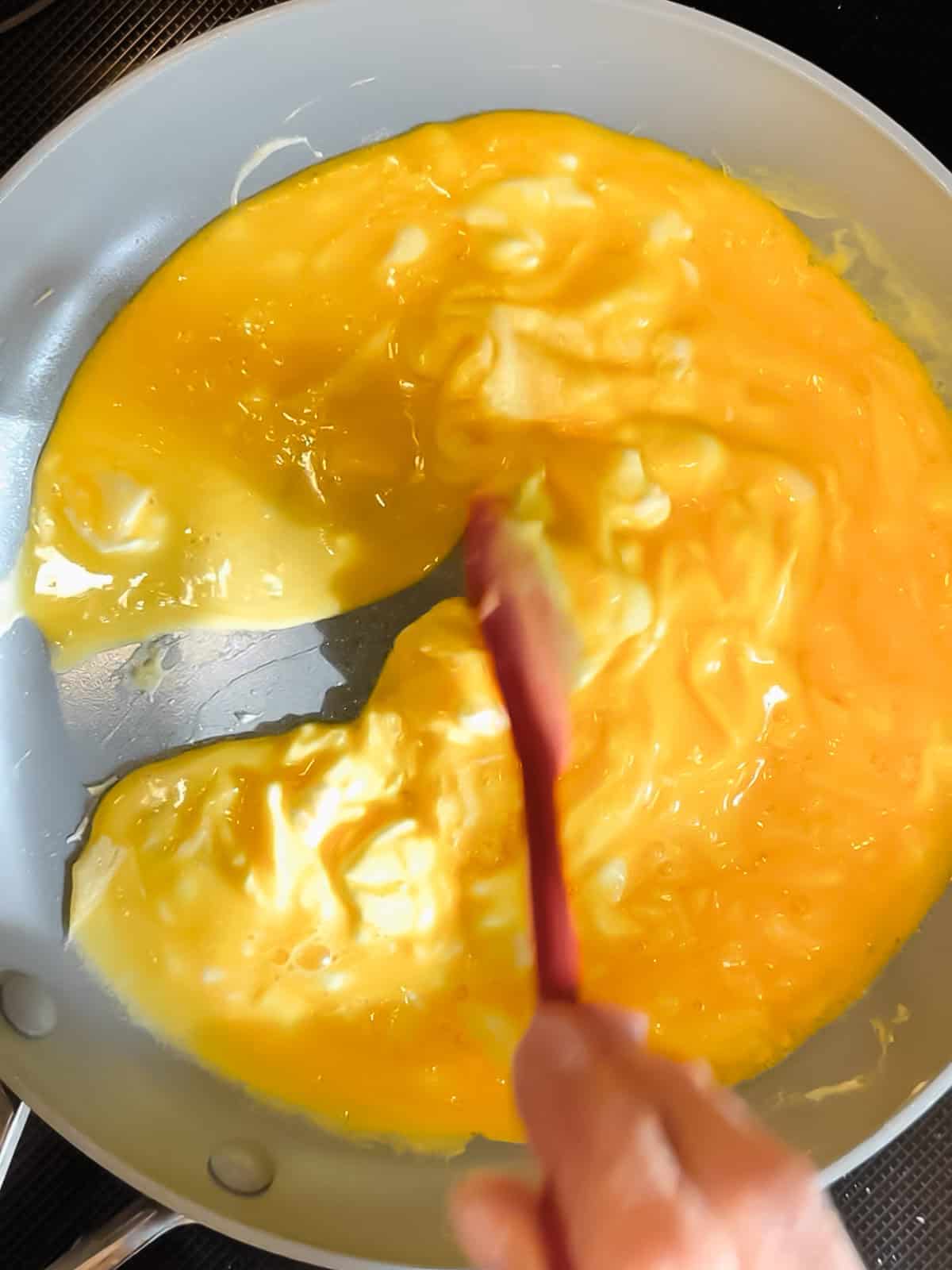Cooking scrambled eggs in a nonstick pan.