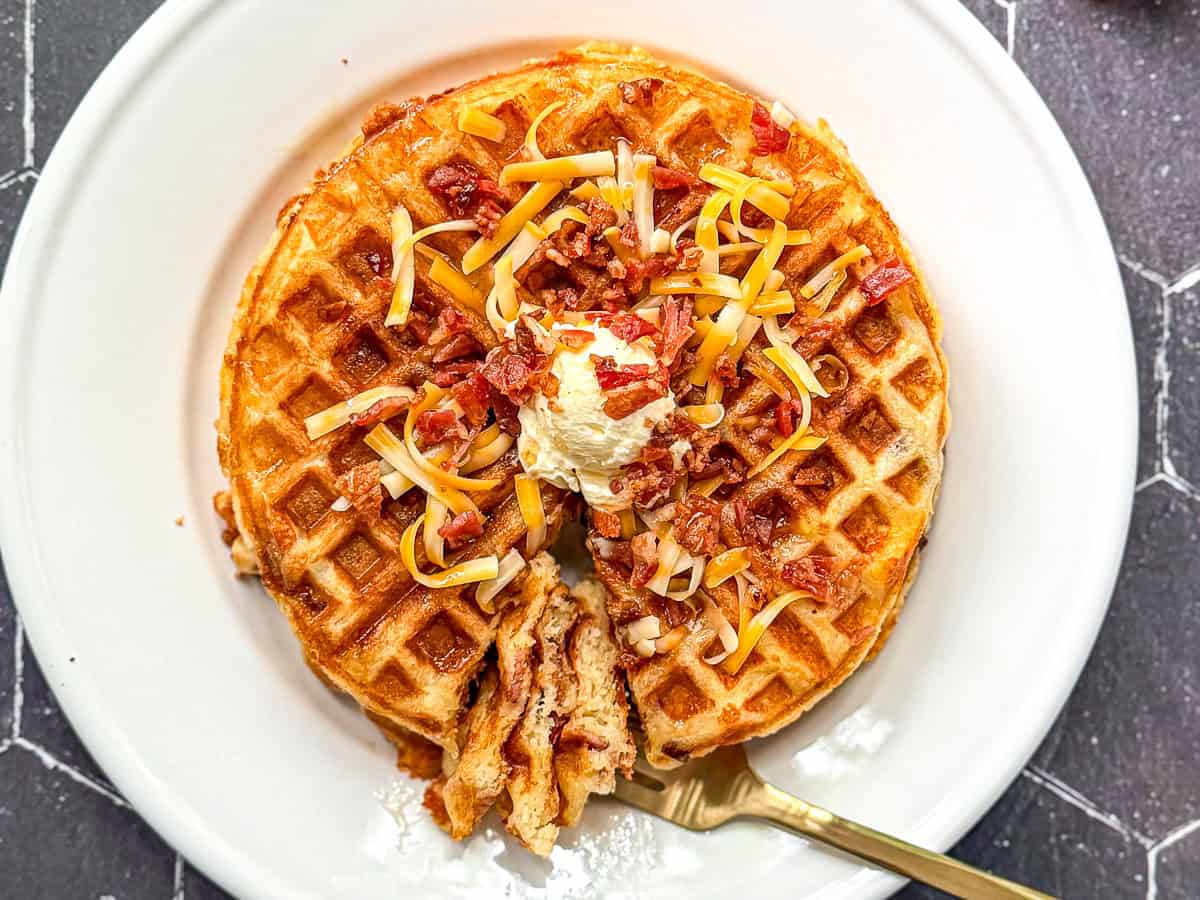 Bacon cheddar waffles with butter, cheddar, and bacon sprinkled on top.