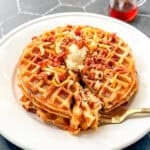 Bacon cheddar waffles with butter, cheddar, and bacon sprinkled on top.