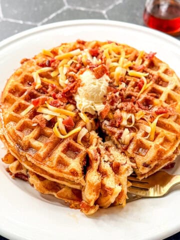 Bacon cheddar waffles with butter, cheddar, and bacon sprinkled on top.