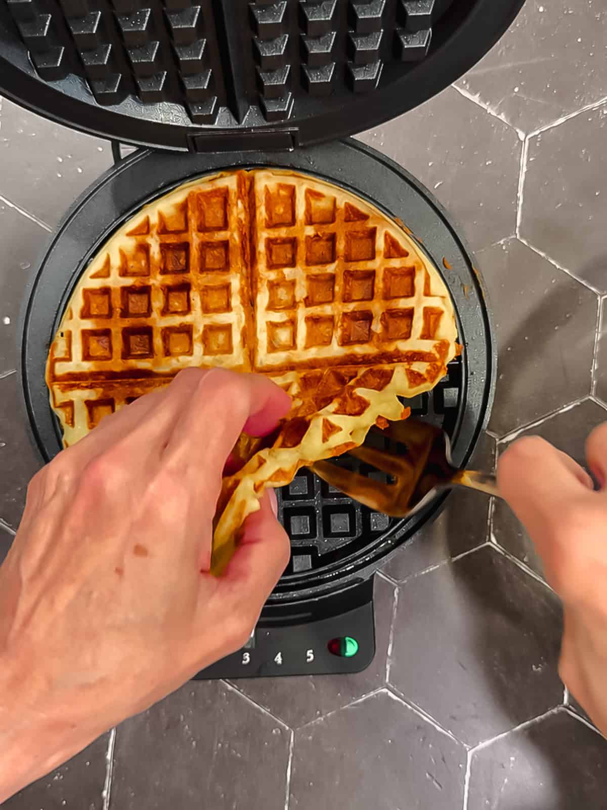 Removing a cooked waffle from the waffle maker.