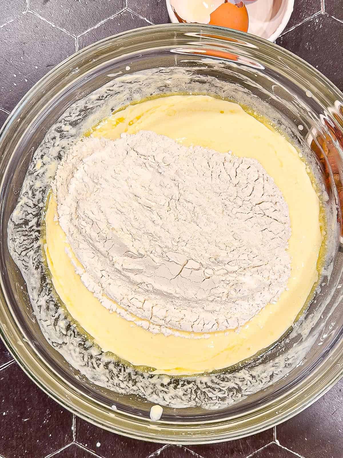 Adding dry ingredients to wet ingredients to make waffles.