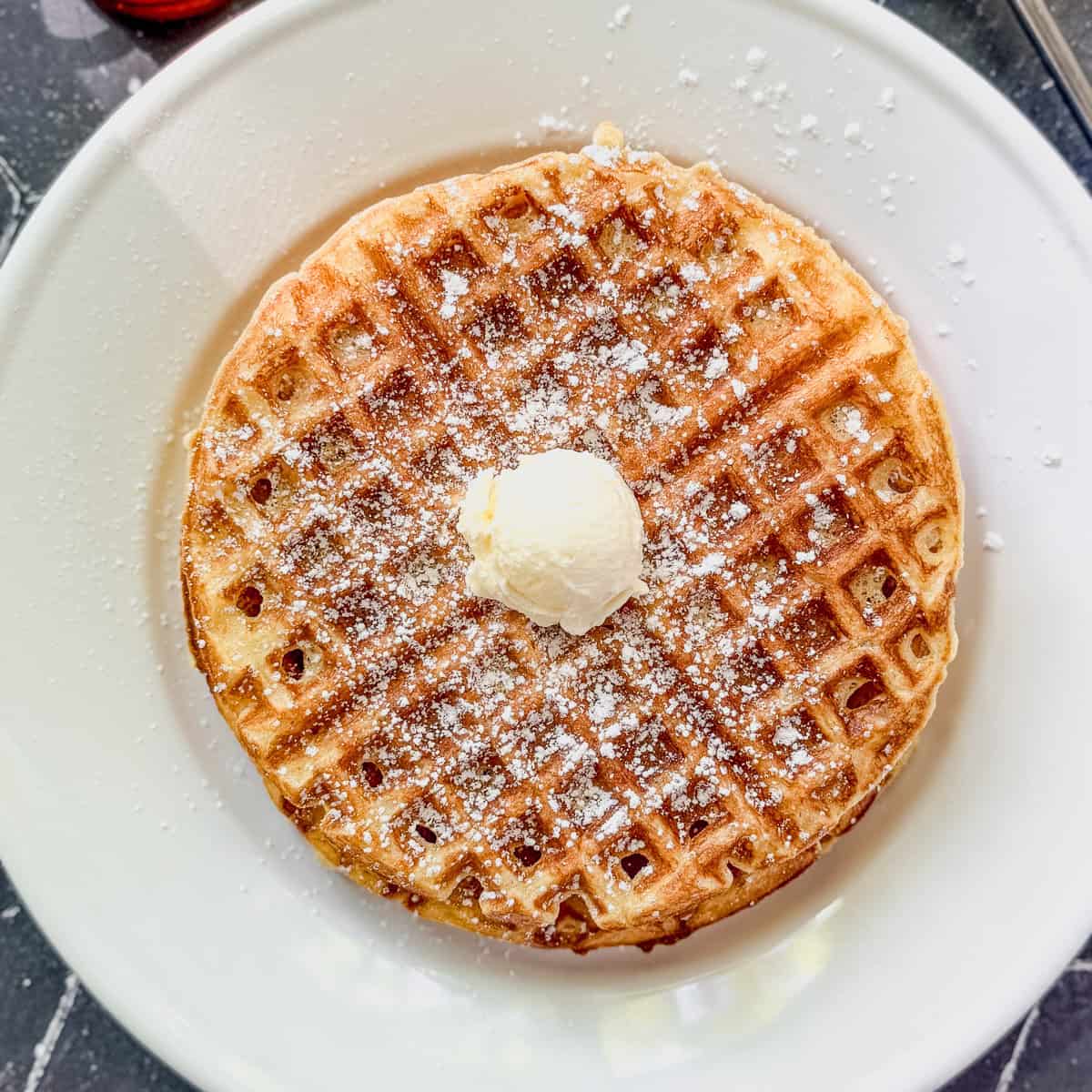 Cornmeal waffles on a white plate.