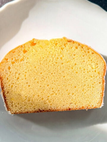 A slice of lemon loaf cake on a white plate.
