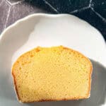 A slice of lemon loaf cake on a white plate.