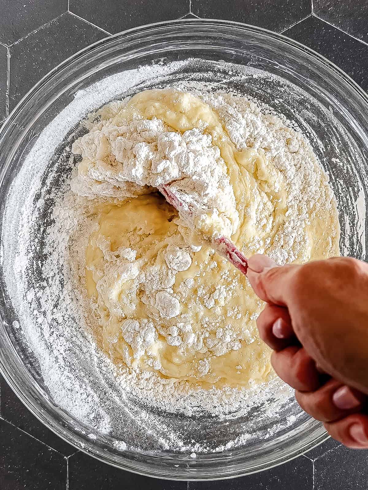 Mixing flour into lemon loaf batter.