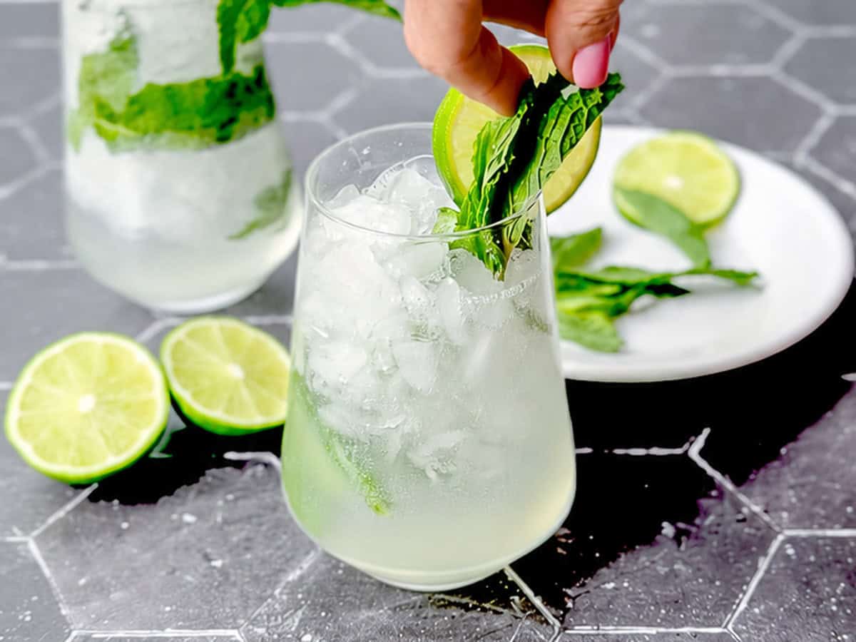 Adding Mint sprig garnish to a mint julep cocktail.