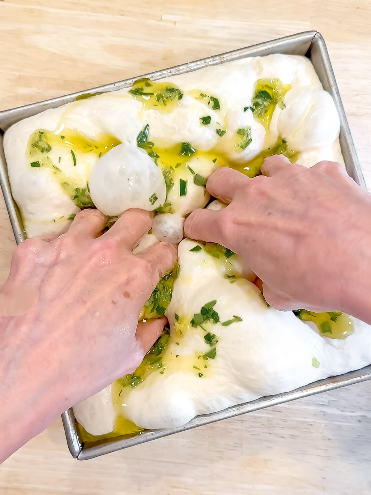 Dumpling rosemary garlic topping into focaccia with fingers.