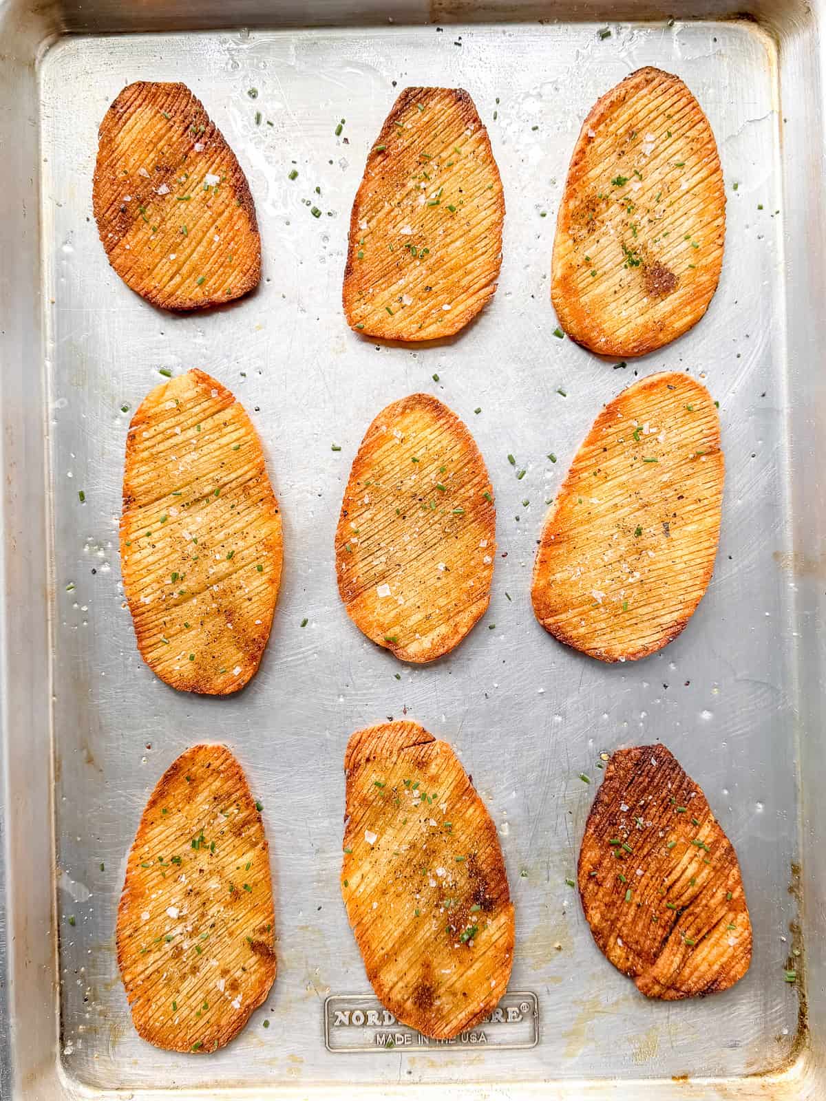 Crispy baked accordion potatoes on a sheet pan.