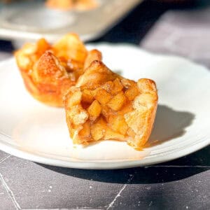 Baked apple croissants on a white plate.