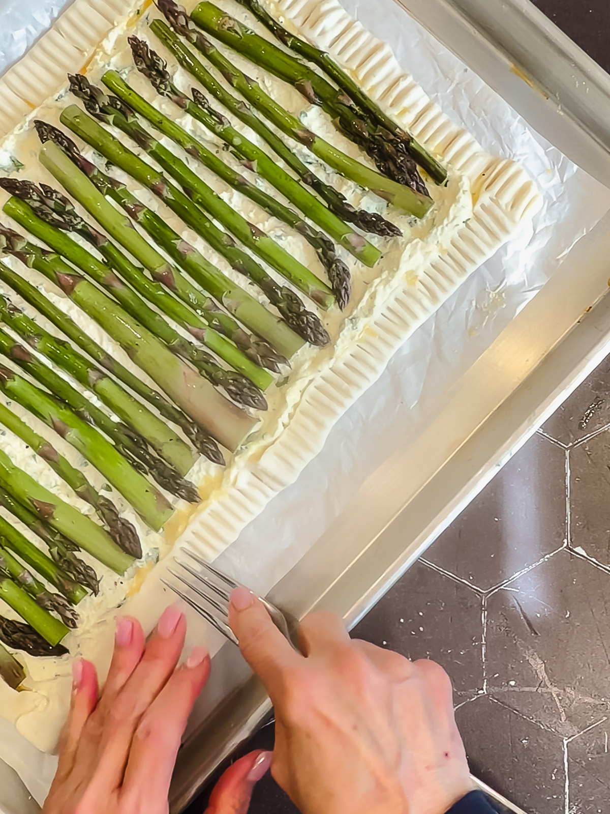 Using the fork to crimp the edges of a puff pastry retard.