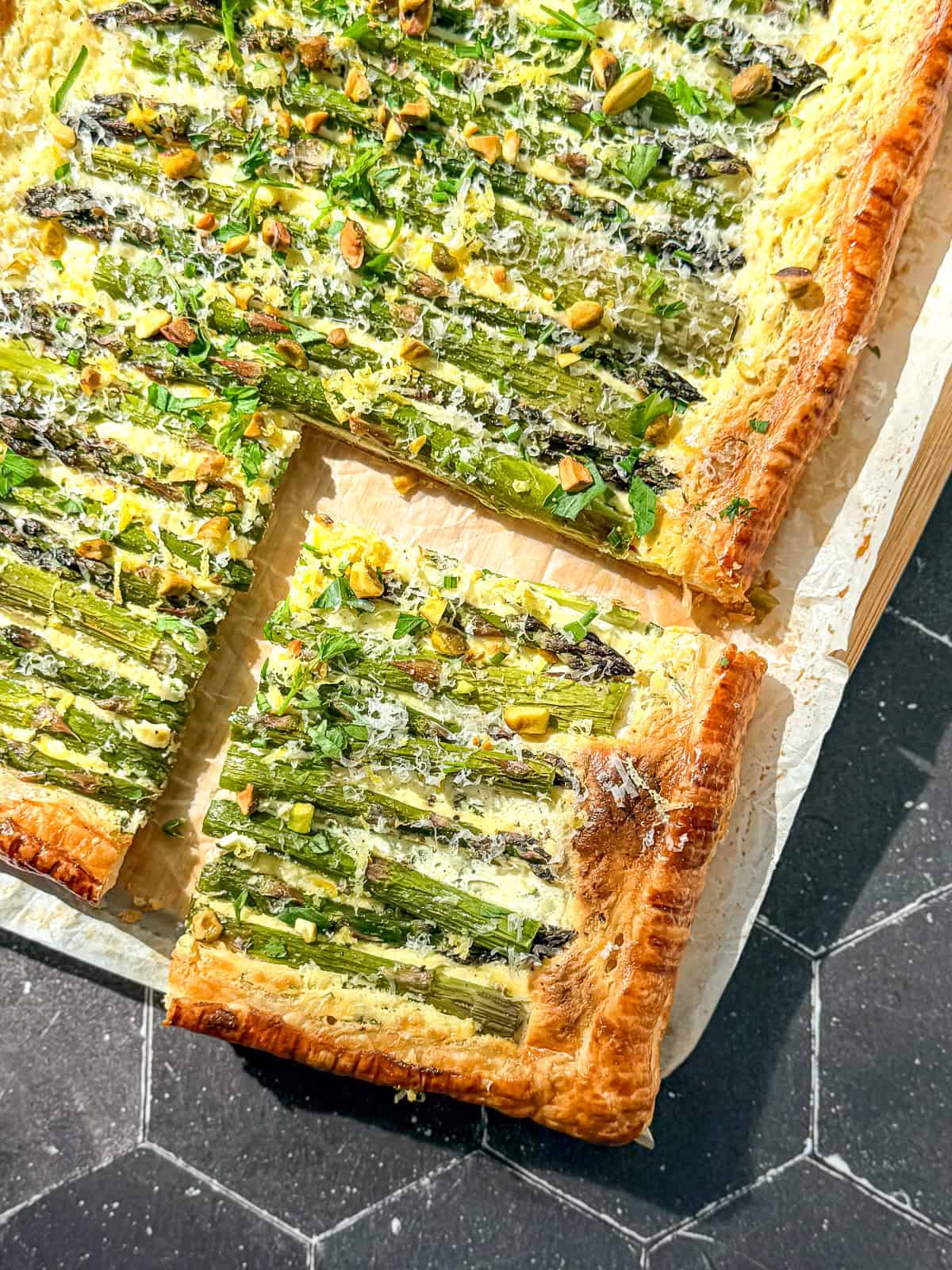 Asparagus puff pastry tart on parchment paper.