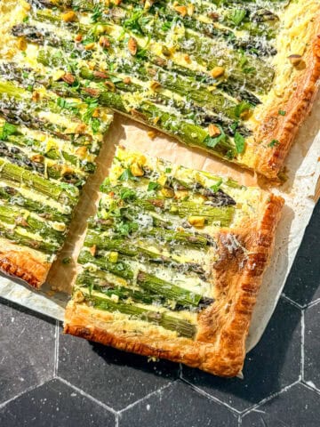 Asparagus puff pastry tart on parchment paper.