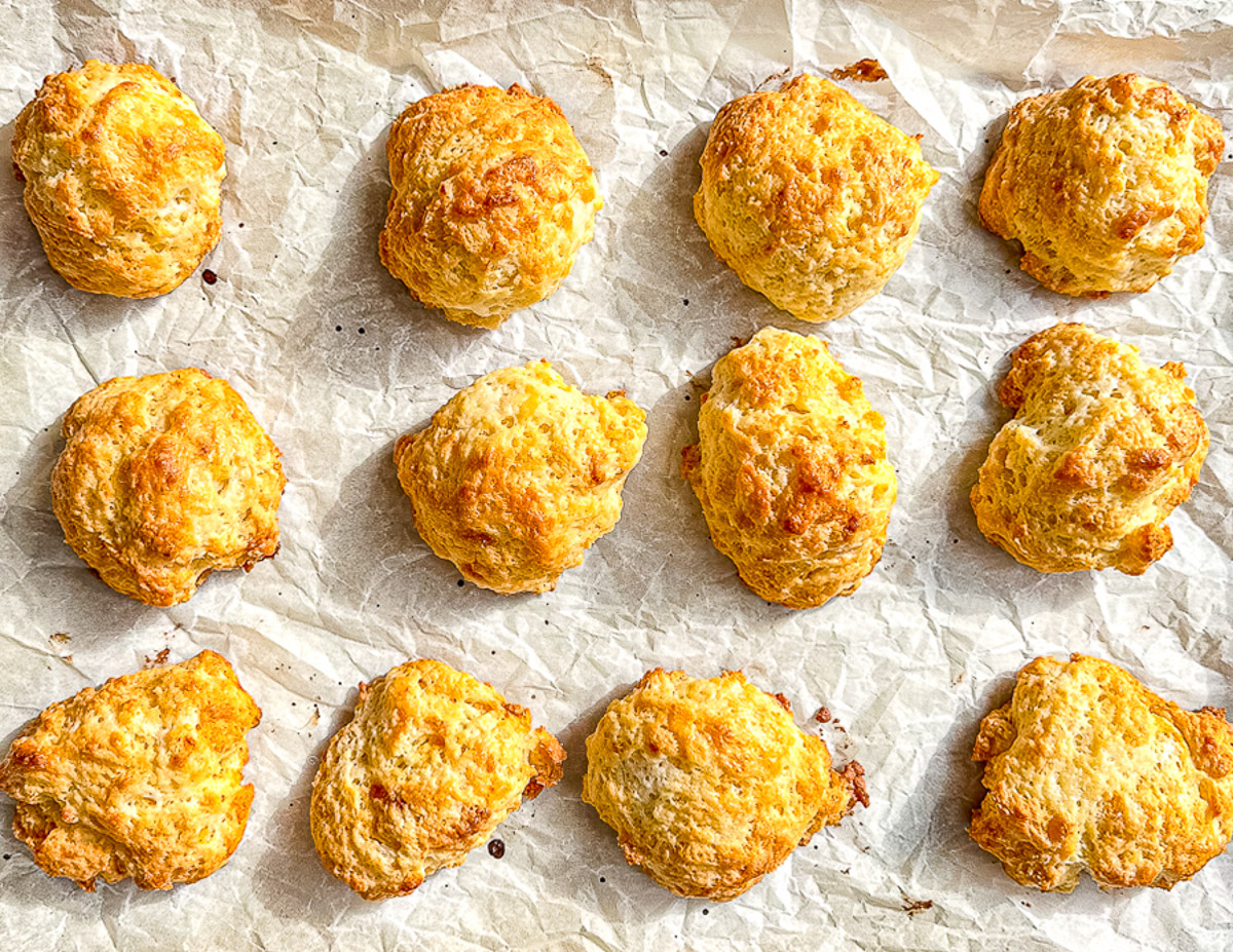 Baked cornbread drop biscuits on parchment paper.