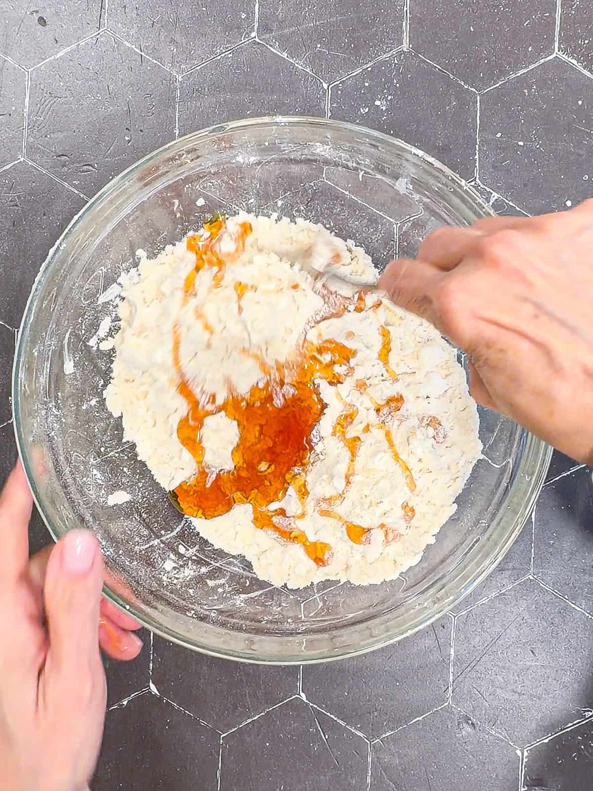Mixing honey into biscuit ingredients using a fork.