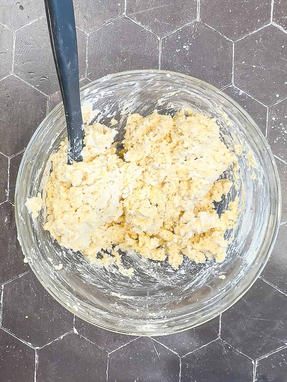 Biscuit dough and a Gray spatula in a glass bowl.
